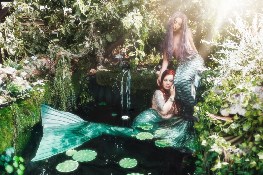 Zwei Meerjungfrauen in einem Teich